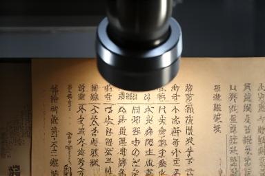 도서관 환경에서 고화질 스캐너를 사용하여 오래된 문서를 디지털화하는 모습